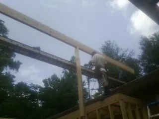Carpenter setting a ridge beam over a new addition frame — Ice Dam Removal by Roofing Brothers in Leola