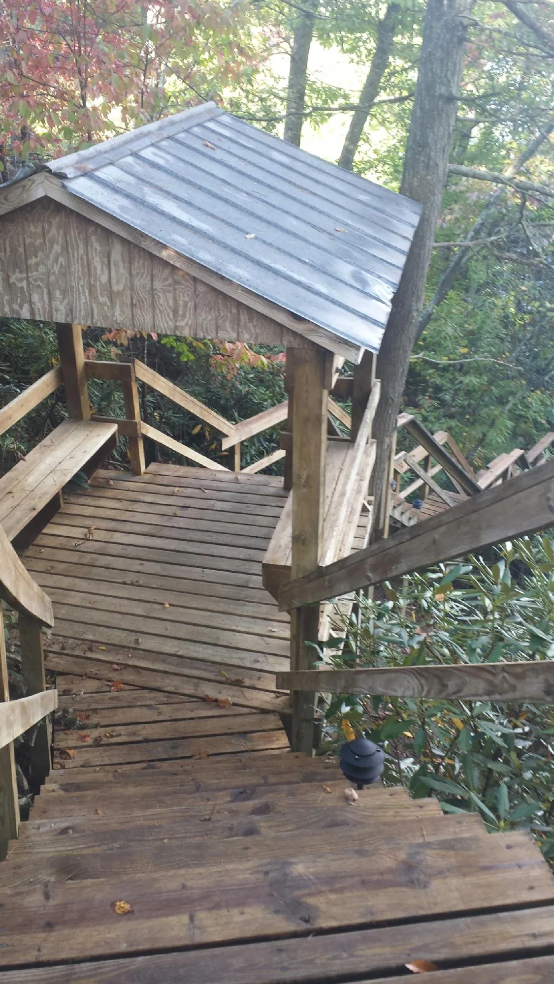 Metal roofed shelter over wooden steps on a wooded walkway — Skylight Repair & Installation work by our crew in Leola