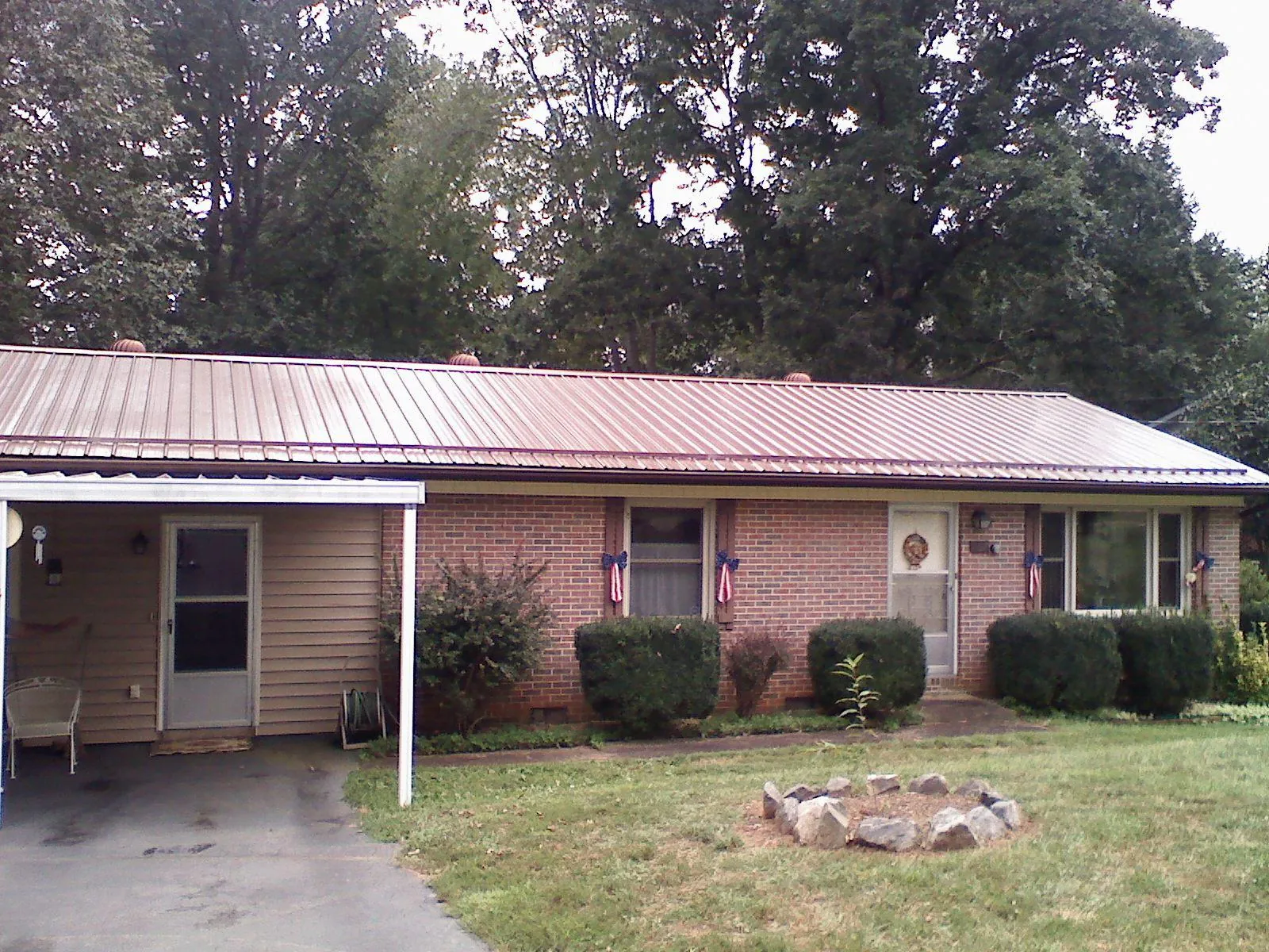 Bronze metal roof and carport on a brick ranch home — Roof Repair work by our crew in Leola
